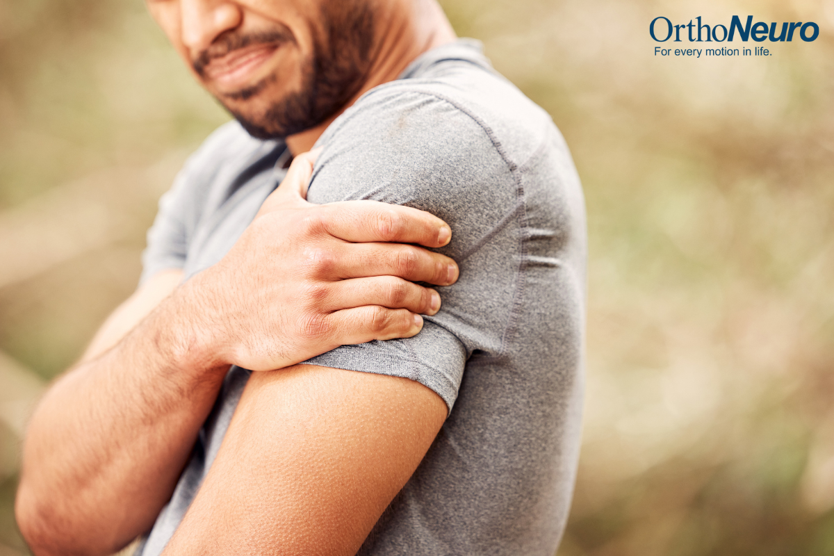 A man holding his shoulder in discomfort after his shoulder popped out of place while taking a walk in Columbus, Ohio.